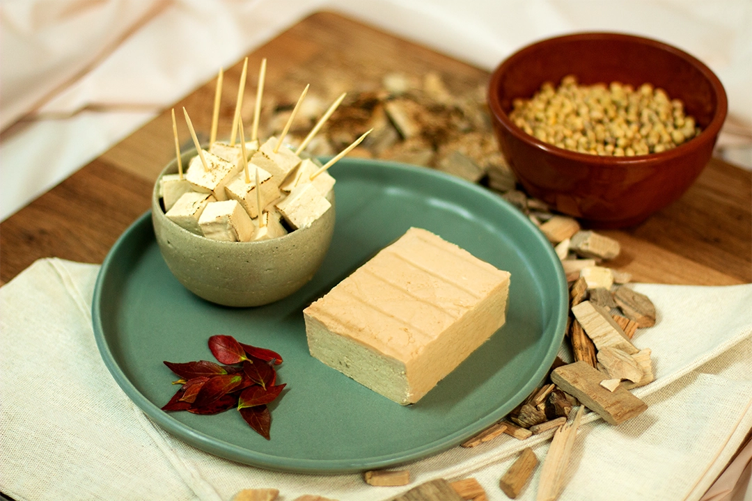 Bloc de tofu fumé présenté dans une assiette et bol contenant des petit cubes de tofu fumé pour l'apéro
