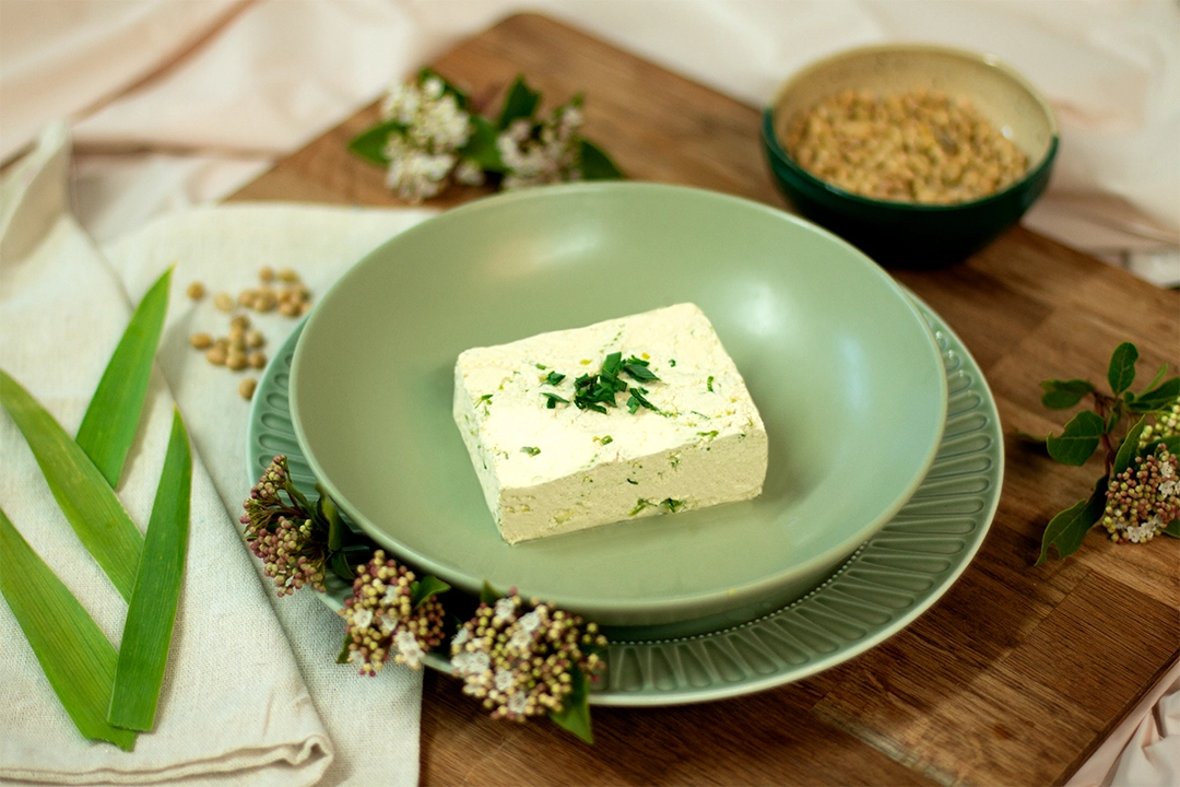 Bloc de tofu à l'ail des ours présenté dans une assiette, décoré avec de l’ail des ours